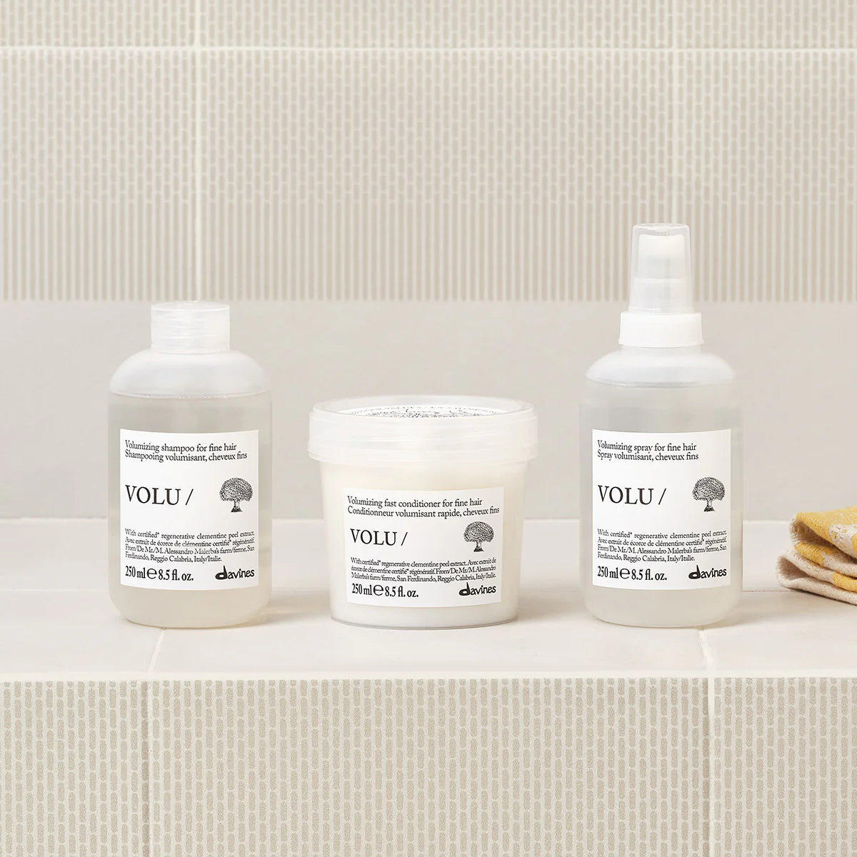 Davines Volu line with white labels on a beige shelf