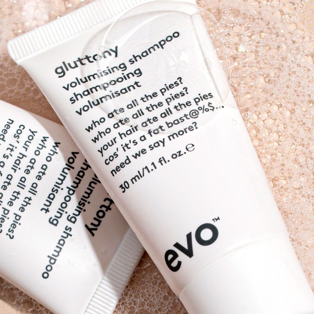 Two tubes of evo volumising shampoo on a textured beige background