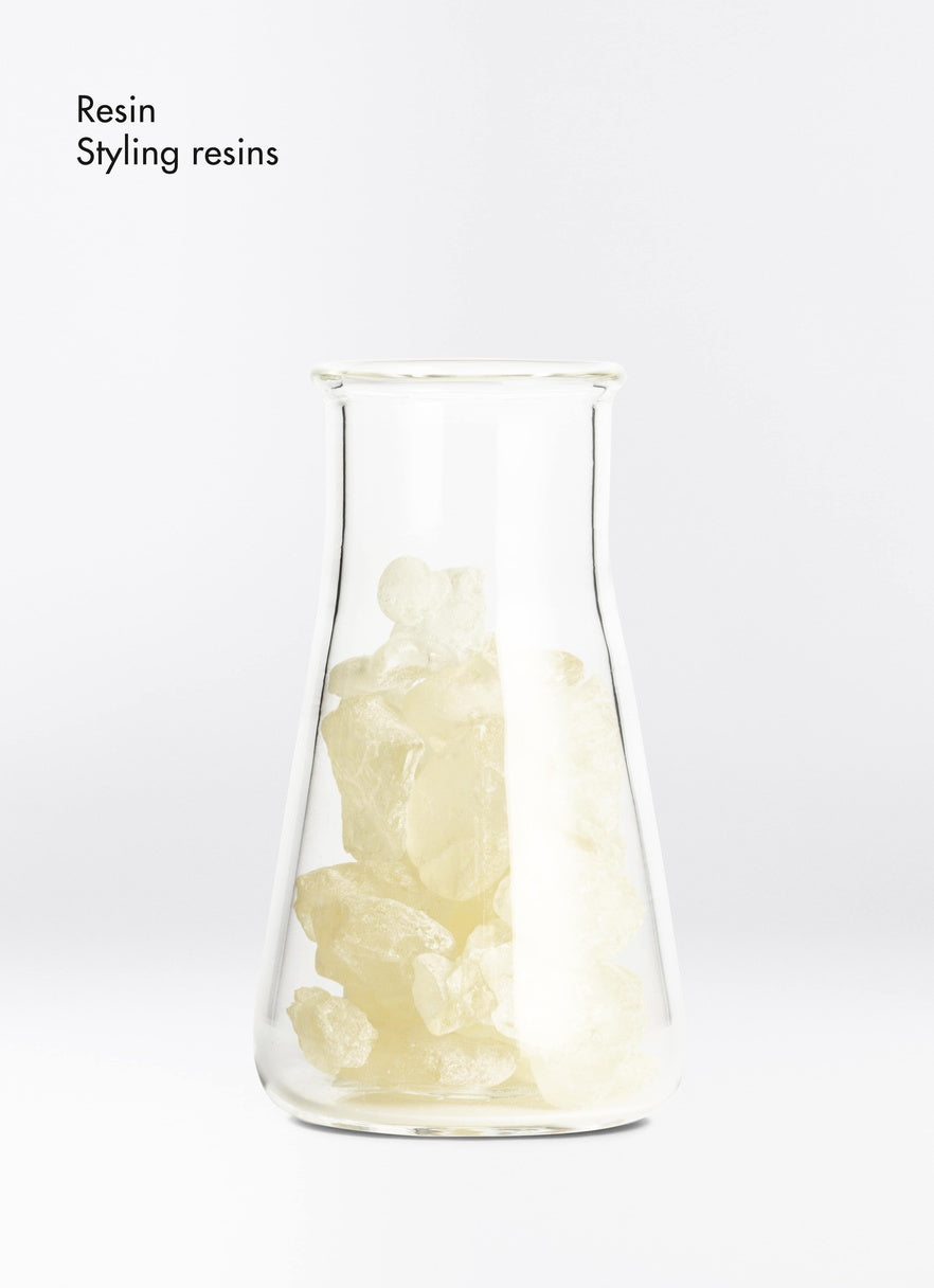 Clear glass container with white resin material on a white background