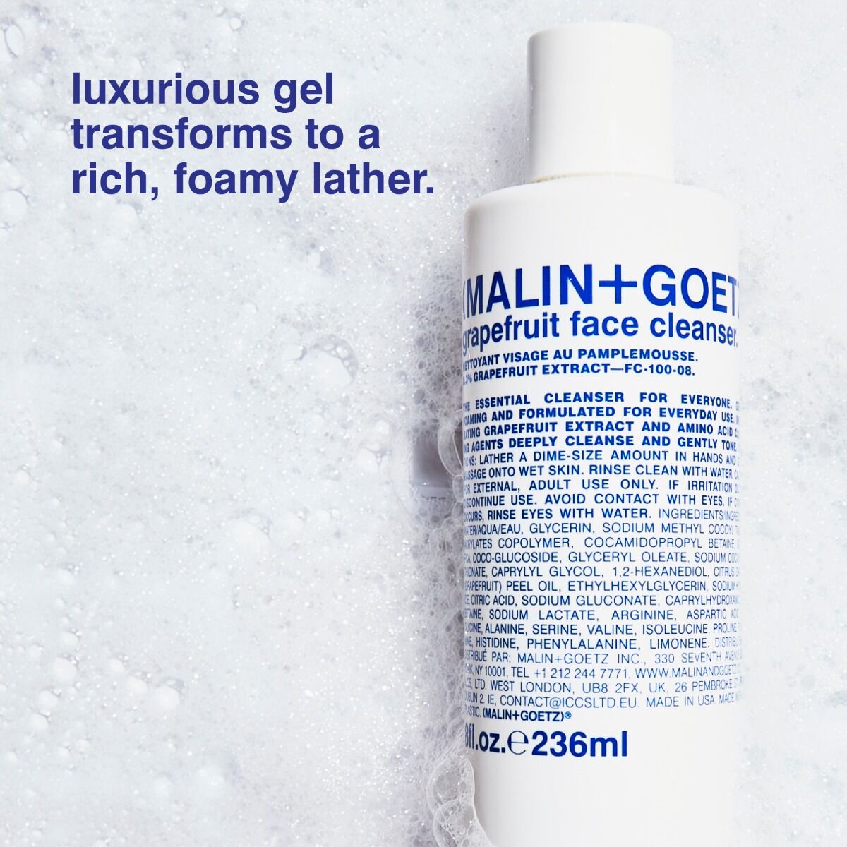 Malin+Goetz grapefruit face cleanser bottle with foamy texture in the background