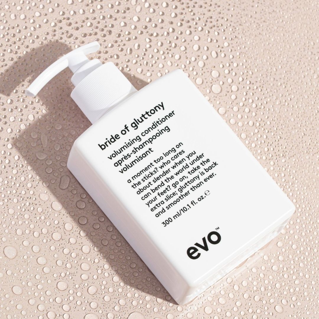White bottle of 'bride of gluttony' volumising conditioner by evo on a textured beige background