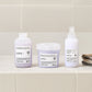 Three Davines hair care products on a bathroom shelf with a tiled wall background