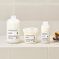 Three Davines hair care products on a bathroom shelf with a tiled wall background