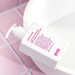 White bottle of evo conditioner with pink text on a pink grid background