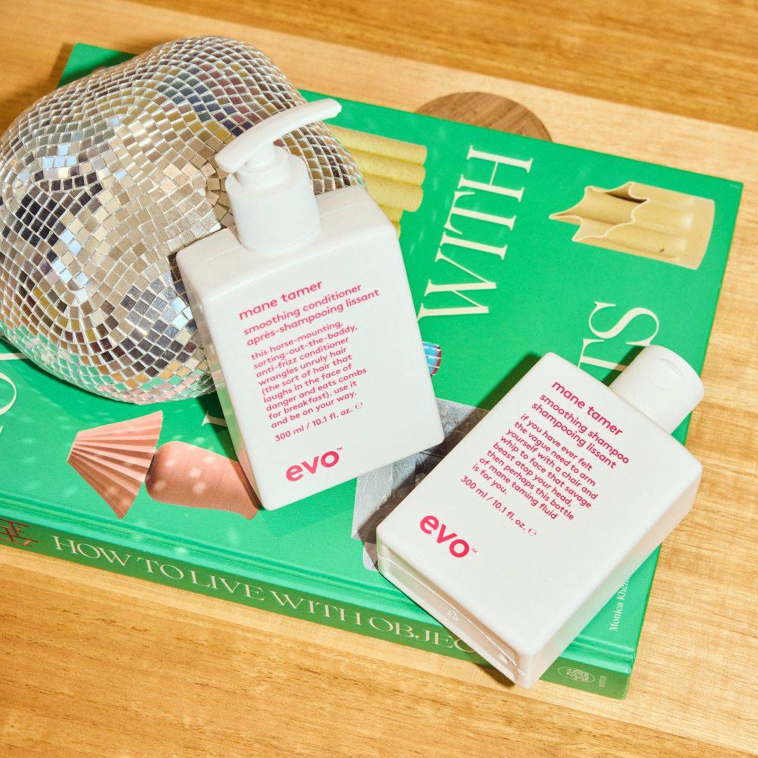 Two Evo hair care products on a book with an irregularly shaped disco ball.