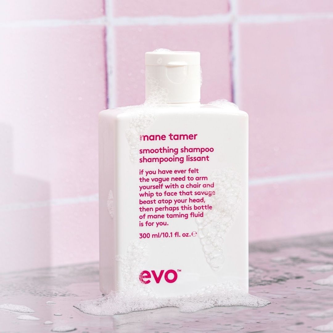 Shampoo bottle labeled 'mane tamer' on a pink tiled background