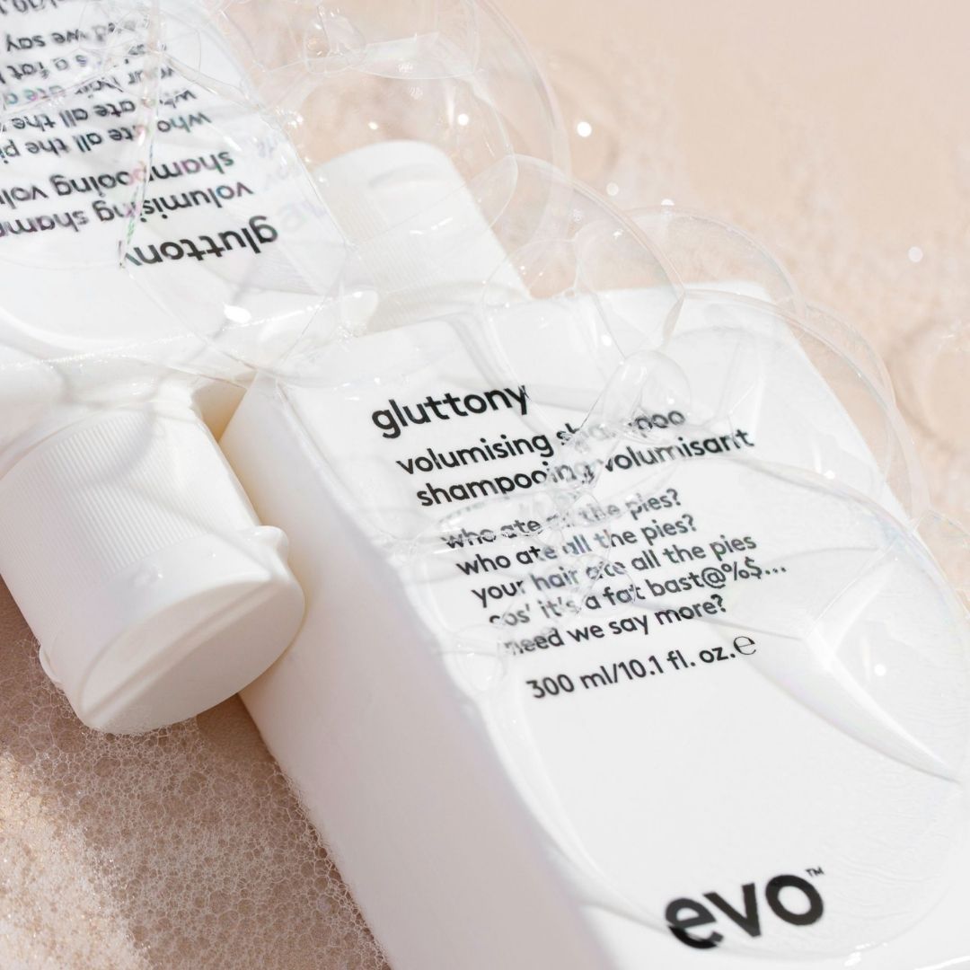 Shampoo bottle with 'evo' branding on a bubbly surface.