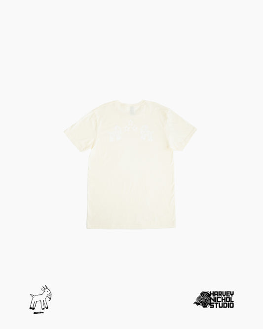 Back of beige shirt against white background with GOAT logo in lower left corner and Harvey Nichol Studio logo in lower right corner