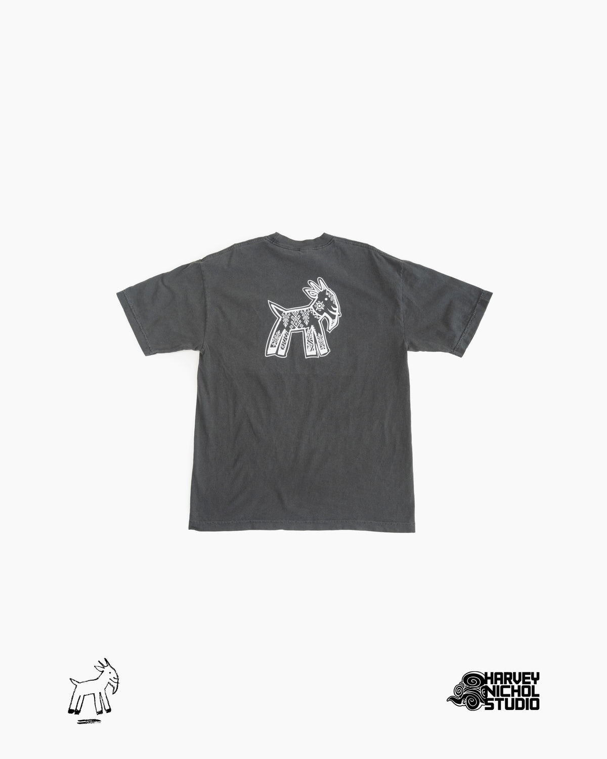 Back of dark grey t-shirt against white background; GOAT logo in lower left corner, Harvey Nichol Studio logo in lower right corner