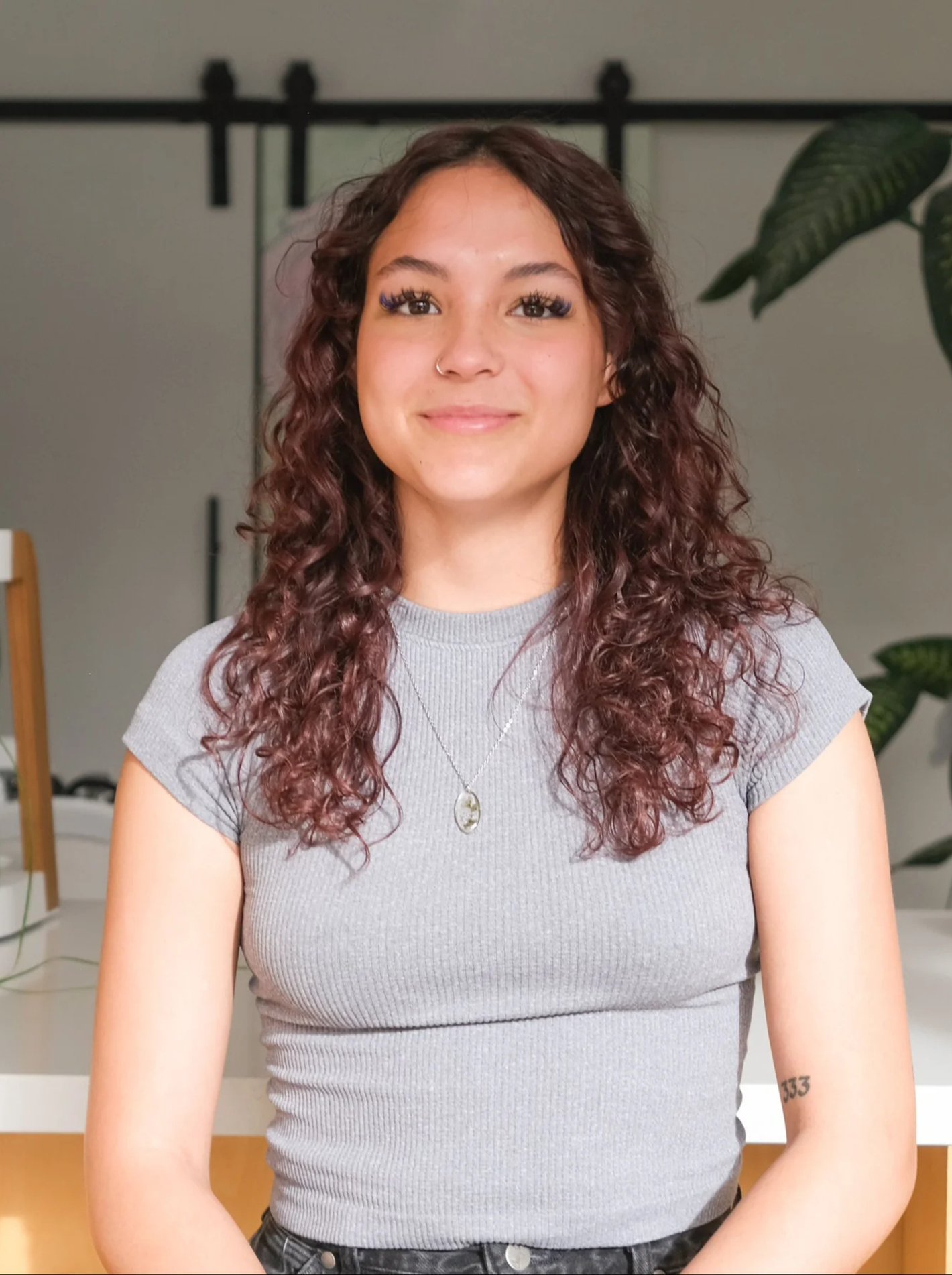 Halle wearing a grey top in front of GOAT's front desk