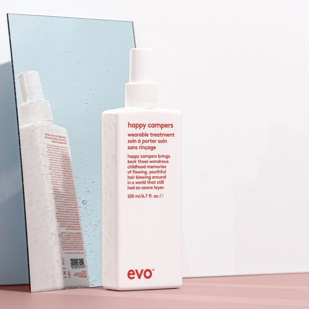 Evo 'happy campers' hair product bottle with packaging on a light background