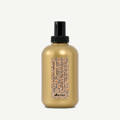 Gold bottle with black cap and decorative label on a white background