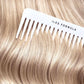 White comb with 'ILES FORMULA' branding on blonde hair