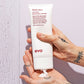 Hand holding a tube of evo liquid rollers curl balm with text on a light purple background