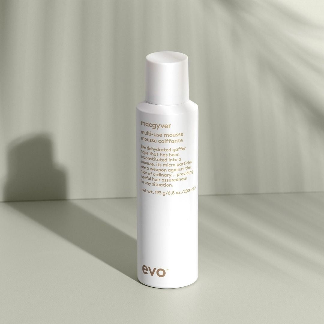 White bottle of evo hair product on a neutral background