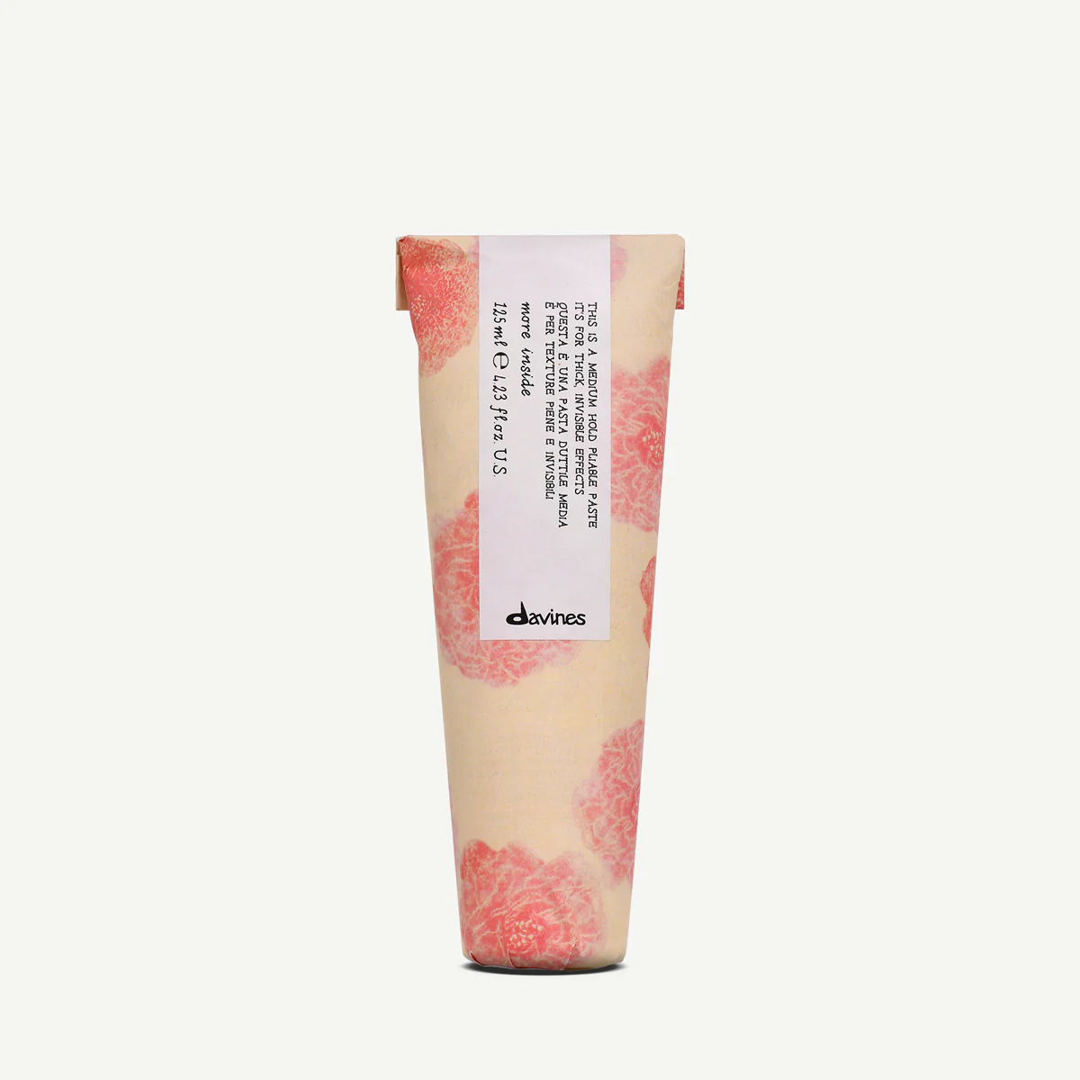 Tube of Davines Medium Hold Pliable Paste with pink and tan design on a white background