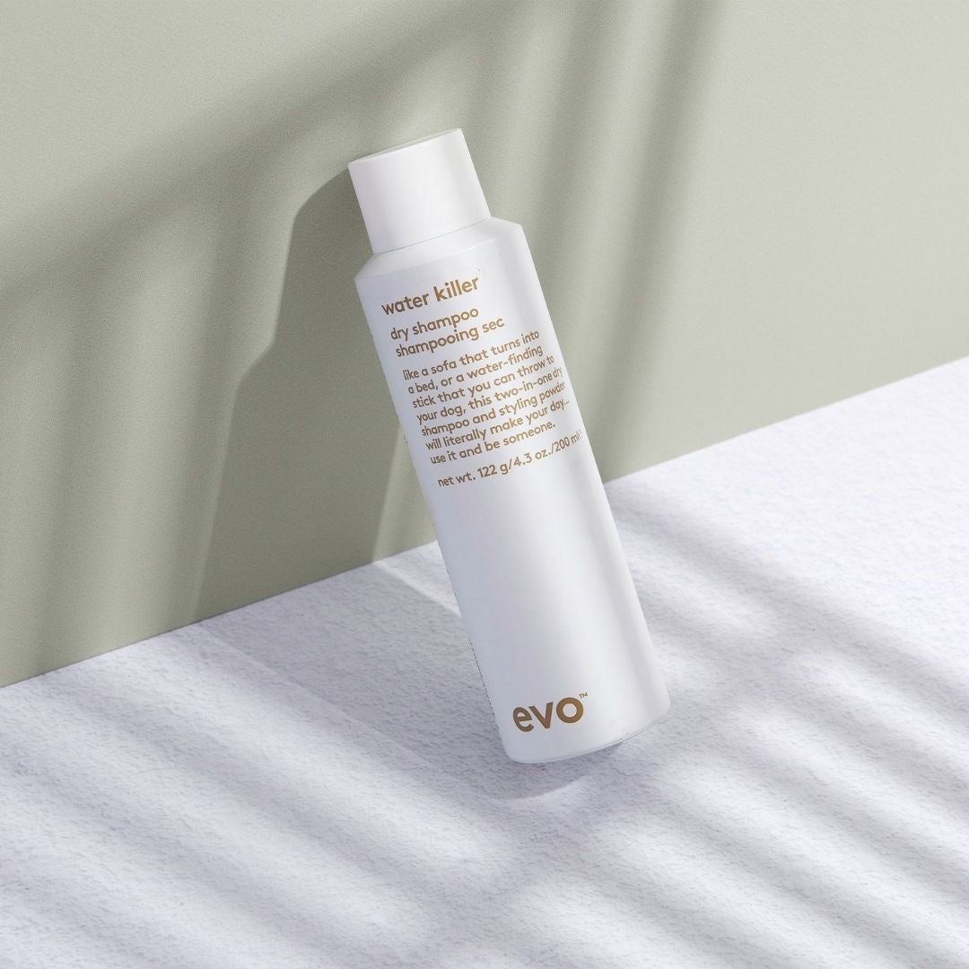 evo water killer dry shampoo bottle on a light surface with a neutral background