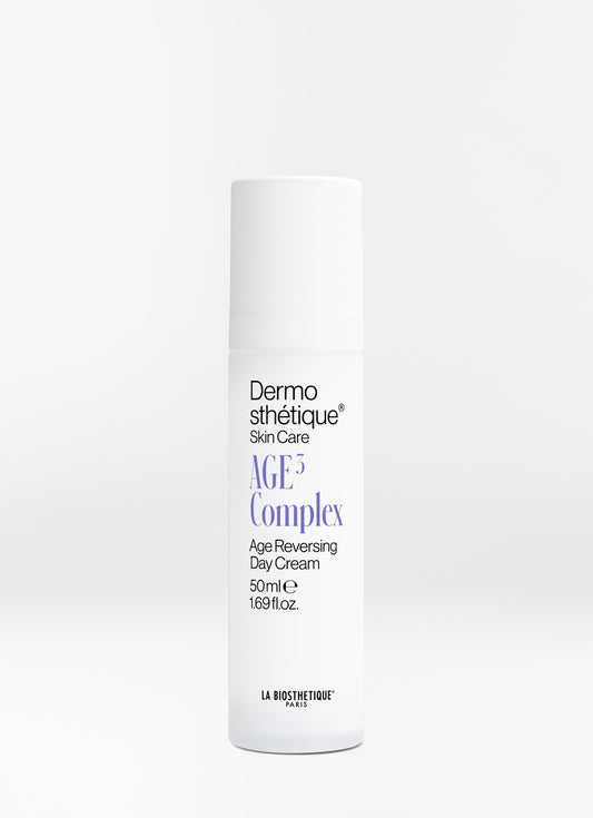 A white cylindrical bottle of Dermosthétique AGE3 Complex Age Reversing Day Cream, 50ml, on a light grey background.