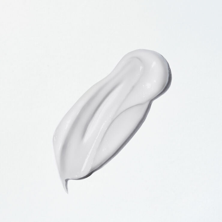 White cream smear on a light gray background