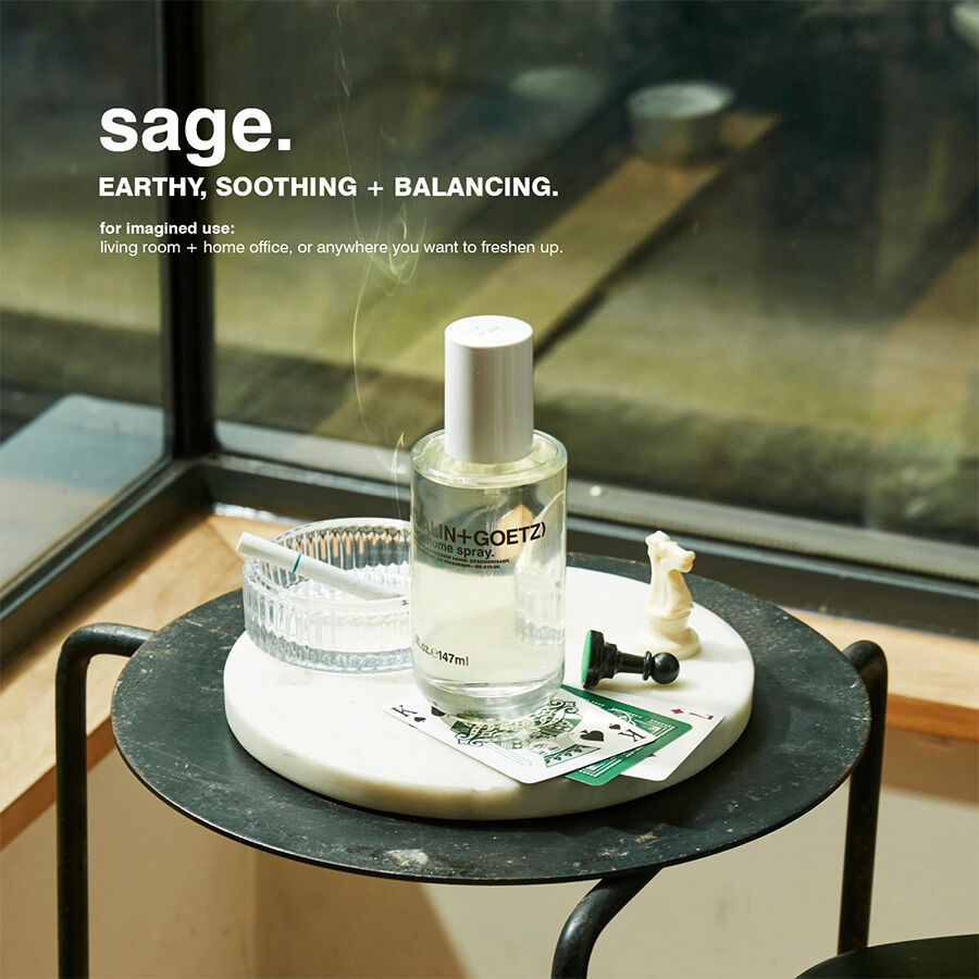 Sage diffuser bottle on a small round table with a blurred background