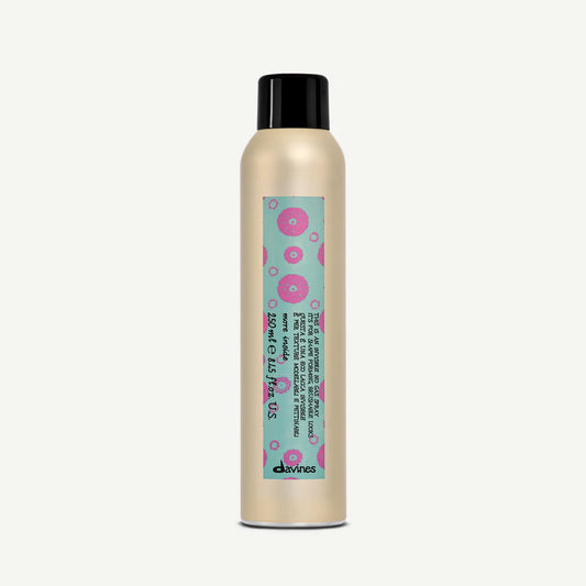 Bottle of Davines Invisible No Gas Spray with a teal and pink label on a white background