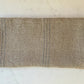 Beige towel with blue stitching on a marble surface