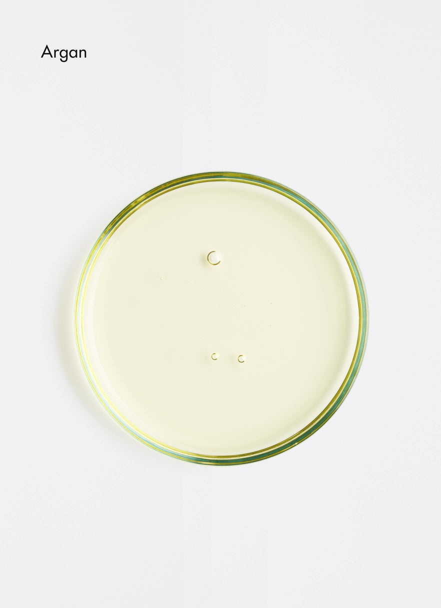 Petri dish of Argan oil on a white background