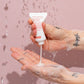 Hand holding a tube of Evo hair shampoo with water droplets on a pink background