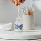 MALIN+GOETZ skincare product with a dropper on a marble surface.