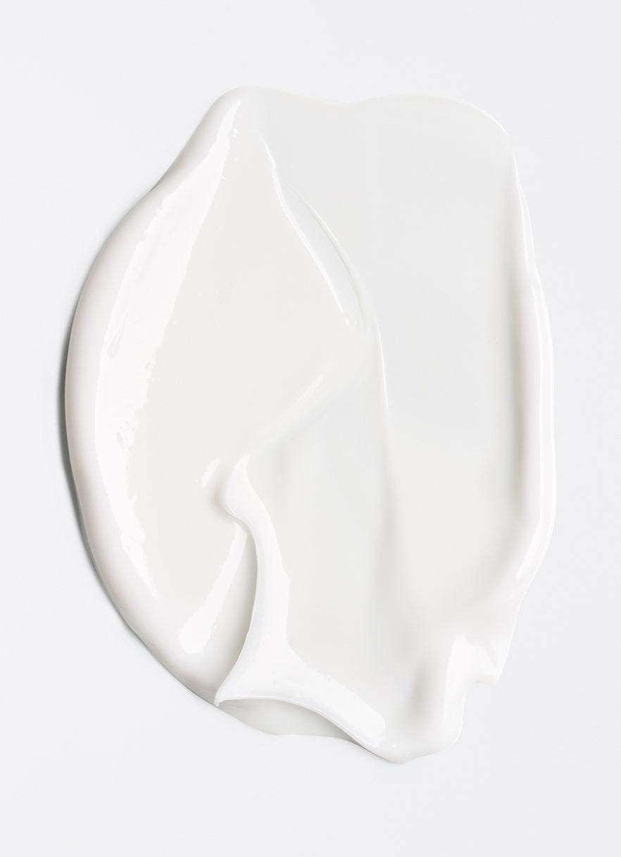 White cream smear on a light gray background