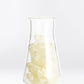 Clear glass container with white resin material on a white background