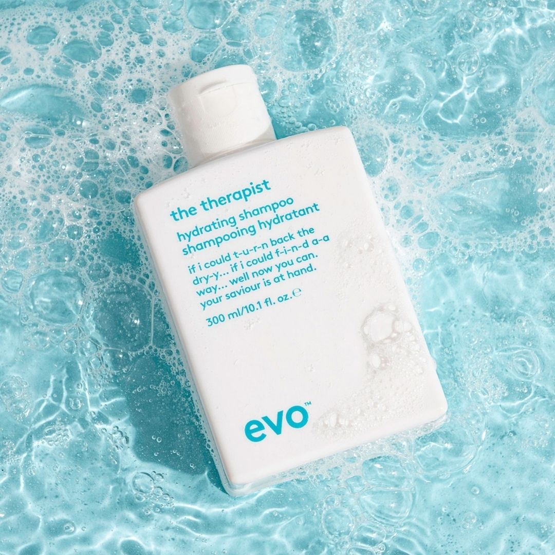 Shampoo bottle labeled 'the therapist' on a blue, bubbly background